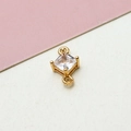 Macro shot of gold-plated geometric rhombus pendant with clear cubic zirconia and dual loops - White