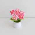Close-up of pink and deep pink hand-knitted lily of the valley in a white ceramic pot - Gradient Pink