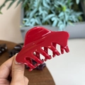 Dettaglio della molletta per capelli rossa lucida che mostra la struttura dei denti incastrati - Rosso Cina