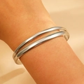 Polished silver stainless steel double-layer open bangle for women shown on wrist - Silver Double Parallel (9915)