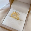 Verstellbarer goldener Blattring mit weißen Zirkonia-Steinen in einer beigen Schmuckschatulle - Blattförmig (J0127) / Einstellbar Offen / Gold
