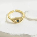 Gedetailleerde opname van gouden boze oog ring met blauwe zirkoon en glinsterende steentjes - Koningsblauw Zirkoon Boze Oog