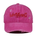 Close-up of distressed pink cotton baseball cap featuring red gothic embroidery text - One Size / Rose Red