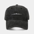 Dettaglio del ricamo bianco 'whatever' su un cappellino da baseball vintage lavato antracite - Nero