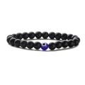 Elastisches Perlenarmband mit mattschwarzen Perlen und blauem Evil-Eye-Anhänger auf Weiß - Matt + Böser Blick