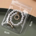 Détail du sachet bijoux anti-oxydation 6x8cm avec collier de perles à l'intérieur - 6*8cm (Lot de 20)