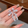 Vue détaillée de boucles d'oreilles nœud argentées avec pompons et finition brillante - 925 Sterling Silver Earring Post - Gland de Nœud - Argent
