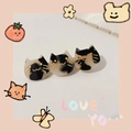 Close-up of cute black and white acetate cat hair clips with shiny finish and art details - Tortoiseshell Cat