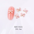 Makro-Detail einer 9x6,5mm rosa Schleife Nagelkunst mit Perle und goldenem Rand - Rosa Emaille Goldrand Schleife (8431)