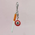 Close-up of a creative 8-ball and cigarette pendant keychain with a metal lobster clasp - Long Cigarette with Red Pool Ball