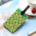 Green PVC luggage tag with colorful 3D dots and black strap on a magazine background - Small Polka Dots