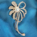Close-up of rose gold brooch with white pearl and rhinestones on blue silk background - Zirconia Flower Brooch