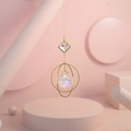 Close-up of golden suncatcher with multi-faceted crystal prism in geometric pink scene - US 7