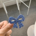 Detailed close-up of blue polka dot bow hair clip with gold metal duckbill attachment - Bow / Blue with Black Polka Dot Bow