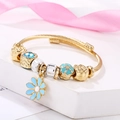 Gold spiral beaded bracelet featuring blue enamel flower charms and clear crystal beads - Blue Daisy