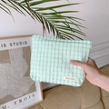 Détail d'une trousse à maquillage à carreaux verts et blancs avec étiquette Sozakka - Vert