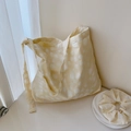 Close-up of a pale yellow polka dot canvas tote bag with a matching scrunchie - Beige Polka Dot Textured