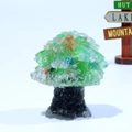 Detail of a colorful crystal resin tree ornament with a rustic wooden sign on white background - Cat's Eye