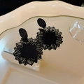 Detailed view of vintage black checkered square earrings on a cream reflective tray - Black Flower and Leaves