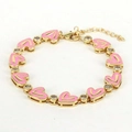 Detail of gold heart bracelet with pink enamel charms and clear zircon stone accents - Pink