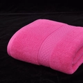 Absorbent pink cotton bath towel featuring wavy woven borders and soft loop pile texture - Rose Red