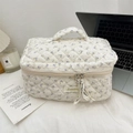 Detailed close-up of quilted floral cosmetic bag with double zippers and top handle - Beige Purple Flower