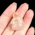 Hand-carved orange agate turtle figurine held in hand to show small size - Natural Agate
