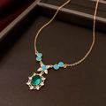 Detailed macro of vintage gold necklace with green gemstone pendant and blue beads - 28# Gold Blue Gemstone Necklace