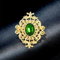 Vintage gold brooch featuring intricate filigree and a large oval green gemstone centerpiece - Hollow Pattern Green Gem Style (YNCP7883)