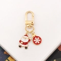 Close-up of golden Santa Claus and red snowflake metal keychain with enamel coating - Santa Claus-7 (with Snowflake)