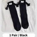 One pair of black magnetic hand-holding mid-calf socks with 3D eyes and tiny arms - One Size / Black