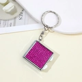Detailed close-up of a silver square keychain set with sparkling pink rhinestones - Rose Red