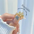 Rotating gold plated flower ring with sparkling crystals and adjustable open band design - Rhinestone Sakura Rotatable Style (H005)