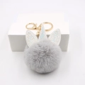 Unicorn plush pom pom keychain with grey faux fur and golden glitter horn on white box - Unicorn Gold Keychain / Light Gray