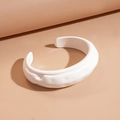 Dettaglio del bracciale aperto in acrilico bianco con texture stropicciata e design d'arte - Bianco