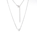 Vue macro du pendentif cœur argenté avec gravure M et chaîne fine à fermoir ajustable - Lettre M / Acier
