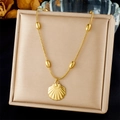 Detalle de colgante de concha dorada con cadena de cuentas ovaladas en joyero de color beige - Diseño de Concha en Cadena de Serpiente Dorada (N3489)