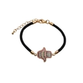 Detailaufnahme des schwarzen geflochtenen Armbands mit goldener Hamsa-Hand und Kristallen - CB000123 / Schwarz