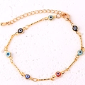 Close-up of gold-plated bracelet featuring colorful evil eye charms and lobster clasp detail - Multicolor Bracelet