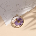 Resin pendant with purple dried flower and gold foil in a circular metal frame - Purple/Gold