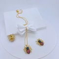 Nahaufnahme von goldenem Spinnen-Schmuckset mit bunten Zirkonia-Kristallen auf weißer Box - Goldener Spinnen Anhänger