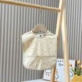 Waterproof baby bib in beige with brown floral pattern and front pocket design - Secret Garden