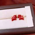 Macro detail of red enamel horse stud earrings with 18k gold plating on beige velvet - Red Gold Flying Horse Style (Silver Needle-Gold Plated)
