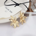 Elegant gold flower earrings featuring layered petal textures on a ceramic plate decor - Golden Sunflower 3D Stud Earrings