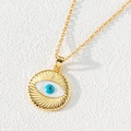 Macro detail of gold evil eye pendant with blue zircon center and textured radiating patterns - Style I-Radial Metal Eye