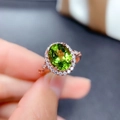 Macro detail of oval green peridot ring with shimmering halo in rose gold finish - Adjustable Open / Peridot Green (Rose Gold Tone)