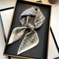 Elegant silk scarf with grey geometric chain print folded in a black display tray - Gray