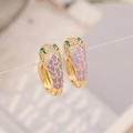 Detailed macro view of gold snake earrings with purple enamel and white zircon inlay - Purple