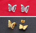 Detail showing gold and silver butterfly earrings with matte and polished metallic finish - Stud Earrings / Steel