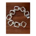 Bracelet chaîne à maillons géométriques épais en argent poli sur fond de bois - Lien Carré / Argenté